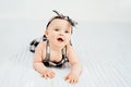 Cute smiling little baby girl sitting on bed. Seven month old infant child on grey soft blanket Royalty Free Stock Photo