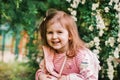 Cute smiling little caucasian girl walking in park outdoors and looking at camera Royalty Free Stock Photo