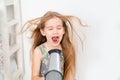 Little girl drying her long hair with hair dryer Royalty Free Stock Photo