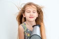 Little girl drying her long hair with hair dryer Royalty Free Stock Photo