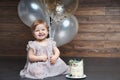 Cute smiling little girl celebrate her first birthday party with balloons and cake Royalty Free Stock Photo