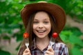 Cute smiling little girl with cherry tomato on green background Royalty Free Stock Photo