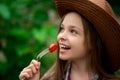 Cute smiling little girl with cherry tomato on green background. Fruit and vegetables at the farm - commercial concept Royalty Free Stock Photo