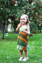 Cute smiling little girl in colorful sundress is playing with soap bubbles in summer park Royalty Free Stock Photo