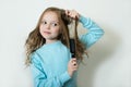 Cute smiling little girl combing her hair comb makes hair Royalty Free Stock Photo