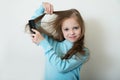 Cute smiling little girl combing her hair comb makes hair Royalty Free Stock Photo