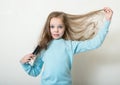 Cute smiling little girl combing her hair comb makes hair Royalty Free Stock Photo
