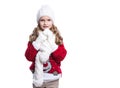 Cute smiling little girl with curly hairstyle wearing knitted sweater, scarf, hat and gloves isolated on white background. Royalty Free Stock Photo