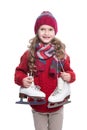 Cute smiling little girl with curly hairstyle wearing knitted sweater, scarf, hat and gloves with skates isolated on white. Royalty Free Stock Photo