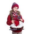 Cute smiling little girl with curly hairstyle wearing knitted sweater, scarf, hat and gloves with skates isolated on white Royalty Free Stock Photo