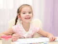 Cute smiling little girl drawing with paint and paintbrush Royalty Free Stock Photo