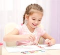 Cute smiling little girl drawing with paint and paintbrush Royalty Free Stock Photo