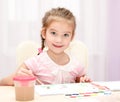 Cute smiling little girl drawing with paint and paintbrush Royalty Free Stock Photo