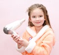 Cute smiling little girl dries hair