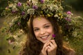 Cute smiling little girl with flower wreath on the meadow at the farm. Portrait of adorable small kid outdoors. Midsummer Royalty Free Stock Photo