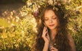 Cute smiling little girl with flower wreath on the meadow at the farm. Portrait of adorable small kid outdoors. Midsummer Royalty Free Stock Photo