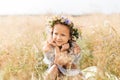 Cute smiling little girl with flower wreath on the meadow. Portrait of adorable small kid outdoors Royalty Free Stock Photo
