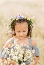 Cute smiling little girl with flower wreath on the meadow. Portrait of adorable small kid outdoors Royalty Free Stock Photo