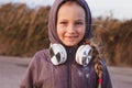 Cute smiling little girl headphones outdoor on beach. Family walking lifestyle Happy kid in earphones listening to music Royalty Free Stock Photo