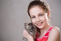 Cute smiling little girl holds funny gray chinchilla. Royalty Free Stock Photo