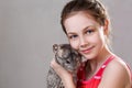 Cute smiling little girl holds funny gray chinchilla. Royalty Free Stock Photo