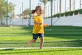 Cute smiling little girl running across green sports field. Royalty Free Stock Photo