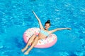 Cute smiling little girl in swimming pool with rubber ring. Child having fun on vacation Royalty Free Stock Photo