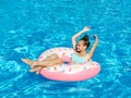 Cute smiling little girl in swimming pool with rubber ring. Child having fun on vacation Royalty Free Stock Photo