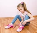 Cute smiling little girl tying her shoes Royalty Free Stock Photo