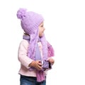 Cute smiling little girl wearing violet knitted scarf and hat, holding christmas gift isolated on white background. Winter clothes Royalty Free Stock Photo