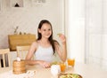 Cute smiling preteen girl having healthy breakfast: avocado sandwich and orange juice. Healthy lifestyle concept, vegetarian food.