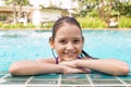 Cute smiling preteen girl at swimming pool edge. Travel, vacation