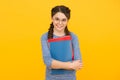 Cute smiling schoolgirl. Girl little schoolgirl. Pupil with braids going to school. Schoolgirl daily life. Take book