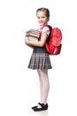 Cute smiling schoolgirl in uniform standing on