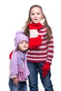 Cute smiling sisters wearing colorful knitted sweater, scarf, hat and gloves isolated on white background. Winter clothes. Royalty Free Stock Photo