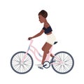 Cute smiling teenage girl dressed in shorts and top riding bicycle. Young woman or female cyclist pedaling pink bike