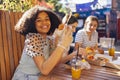 Cute smiling teenage girls are sitting in open air cafe and eating fast food Royalty Free Stock Photo