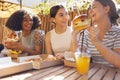 Cute smiling teenage girls are sitting in open air cafe and eating fast food Royalty Free Stock Photo