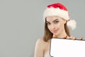 Cute smiling woman in Santa hat with smartphone. Xmas model holds cell phone with blank empty white screen display. Mockup banner