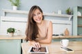 Cute smiling woman using digital tablet at home. Student girl reading or searching recipe. Online shopping, work from home concept Royalty Free Stock Photo