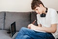 Cute smiling young teenager with laptop on the couch at home. Royalty Free Stock Photo