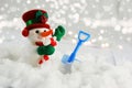 Cute snowman nestled in snow with shovel Royalty Free Stock Photo