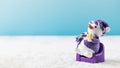 Cute snowman on purple toy armchair and red Christmas tree baubles on snow Royalty Free Stock Photo