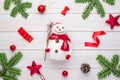 Cute snowman toy on white wooden desk surrounded with Christmas decorations Royalty Free Stock Photo