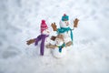 Cute snowmen standing in winter Christmas landscape. Happy winter snowman family. Mother snow-woman, father snow-man and