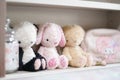 Cute soft plushes. Lovely dolls are sitting on the little girl`s Royalty Free Stock Photo