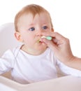 Cute, spoon and baby eating vegetables in feeding chair in a studio for health and nutrition. Sweet, natural and boy Royalty Free Stock Photo