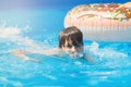 Cute sporty boy swims in the pool with donut ring and has fun, smiles, holds oranges. vacation with kids, holidays, active weekend Royalty Free Stock Photo