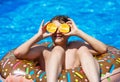 Cute sporty boy swims in the pool with donut ring and has fun, smiles, holds oranges. vacation with kids, holidays, active weekend Royalty Free Stock Photo