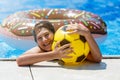 Cute sporty boy swims in the pool with donut ring and has fun, smiles, holds oranges. vacation with kids, holidays, active weekend Royalty Free Stock Photo